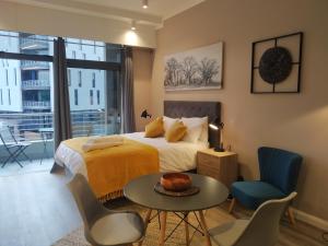 a bedroom with a bed and a table and chairs at Menlyn Residence - Luxury Studio Apartment in Pretoria