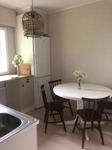 a kitchen with a table and chairs and a refrigerator at Viihtyisää ja helppoa majoitusta 16 in Alavieska