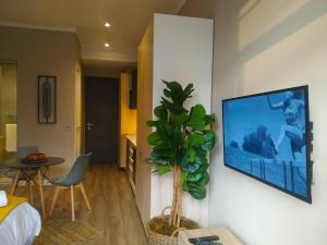 a living room with a flat screen tv on a wall at Menlyn Residence - Luxury Studio Apartment in Pretoria