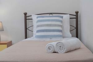 a bed with two towels on it with a pillow at Tzortzi's Family Apartments in Kaloi Limenes