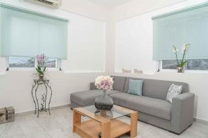 a living room with a couch and a table at Tzortzi's Family Apartments in Kaloi Limenes