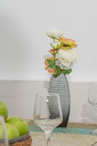 a vase with flowers in it next to a glass at Tzortzi's Family Apartments in Kaloi Limenes