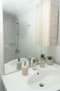 a bathroom sink with two soap dispensers on it at Tzortzi's Family Apartments in Kaloi Limenes