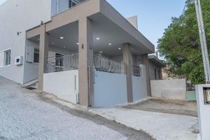 a house with a white garage door on a street at Tzortzi's Family Apartments in Kaloi Limenes