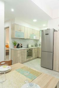a kitchen with a stainless steel refrigerator and a table at Tzortzi's Family Apartments in Kaloi Limenes