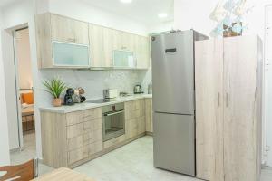 a kitchen with a stainless steel refrigerator and wooden cabinets at Tzortzi's Family Apartments in Kaloi Limenes