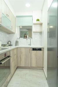 a kitchen with wooden cabinets and a sink at Tzortzi's Family Apartments in Kaloi Limenes
