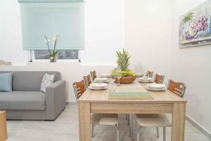 a dining room with a table and a couch at Tzortzi's Family Apartments in Kaloi Limenes
