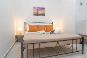 a bedroom with a bed with orange pillows at Tzortzi's Family Apartments in Kaloi Limenes