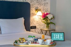 a tray of food on a bed with a tray of food at Bloom Hotel Rome in Rome