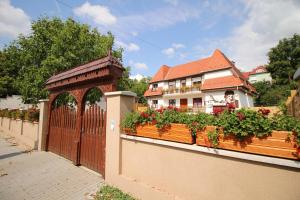 een huis met een hek en een hek met bloemen bij Székely Kúria in Miskolctapolca