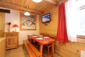 une salle à manger avec une table en bois et un rideau rouge dans l'établissement la levanna, à Les Deux Alpes