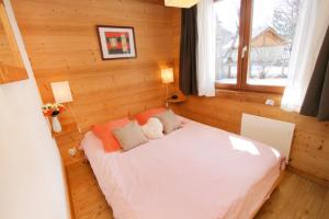 Cette chambre en bois comprend un lit blanc. dans l'établissement la levanna, à Les Deux Alpes