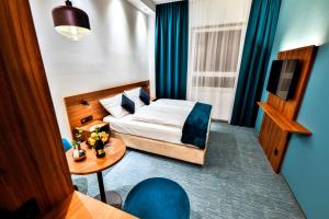 a hotel room with a bed and a table at Hotel Das Zeit in Lenzing