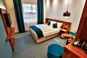 a hotel room with a bed and a table and a room at Hotel Das Zeit in Lenzing