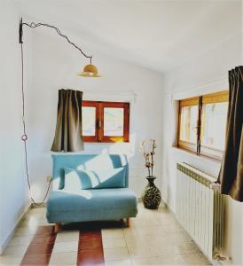a living room with a blue chair and window at B&B Agorà in Biccari