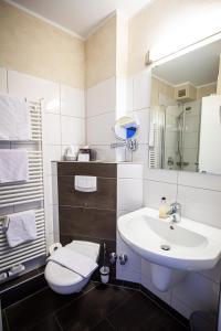 bagno bianco con lavandino e servizi igienici di Hotel Spessartstuben a Haibach