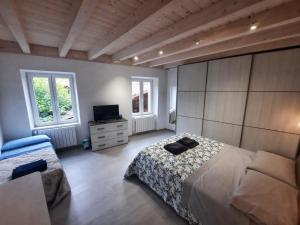 a bedroom with a bed and a television in it at Casa Tilde Guest House in Cunardo