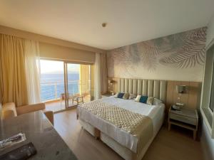 a bedroom with a large bed and a large window at Charisma De Luxe Hotel in Kuşadası