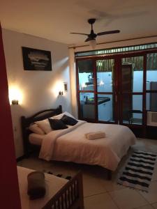 1 dormitorio con 1 cama grande y balcón en Canto do Buganville, en Abraão