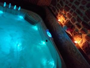 a jacuzzi tub with lights in a room at Le Ptit Spa de L'Abbaye Suite love et Spa privé in Lonlay-lʼAbbaye