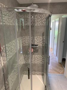 a walk in shower with a glass enclosure at Tenby Flat in Pembrokeshire