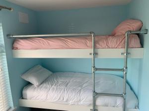two bunk beds in a room with a blue wall at Tenby Flat in Pembrokeshire