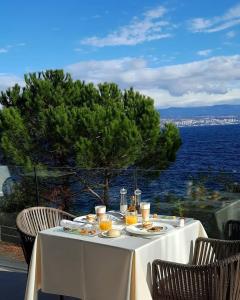 a table with food and drinks on it with a view of the water at Boutique Hotel Acacia in Lovran