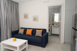 a living room with a blue couch and a table at Tzortzi's Family Apartments in Kaloi Limenes