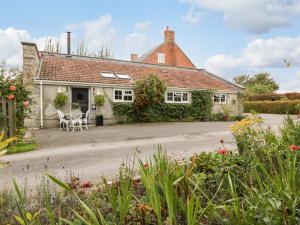 a house with a table and chairs in front of it at Pear Tree Cottage in Mark