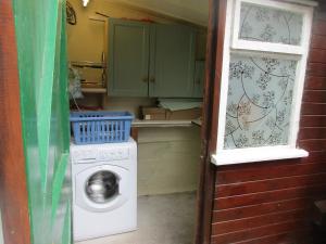 a laundry room with a washing machine and a window at Rose Cottage in Chinley +13 photos