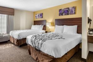 Una habitación de hotel con dos camas y una ventana. en Sleep Inn Henderson I-85, en Henderson 21 fotos más
