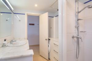 uma casa de banho branca com um chuveiro e um lavatório. em Pyr Aparthotel studio em Fuengirola