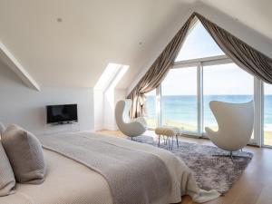 a bedroom with a large window with a view of the ocean at Seascape in Polzeath