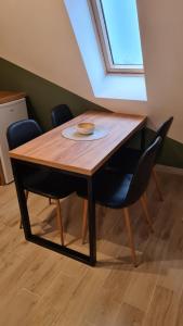 a wooden table with chairs and a plate on it at Apartman Maslacak in Divčibare