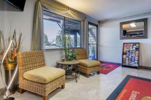 een woonkamer met 2 stoelen, een tafel en een raam bij Econo Lodge Ellensburg Near University in Ellensburg