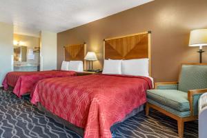 um quarto de hotel com duas camas e uma cadeira em Econo Lodge Ellensburg Near University em Ellensburg