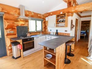 a kitchen in a log cabin with a counter at Cedar Cabin in Worcester