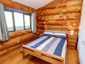 a bedroom with a bed in a log cabin at Cedar Cabin in Worcester