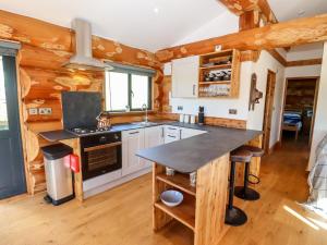 a kitchen in a log cabin with a counter top at Douglas Cabin in Worcester