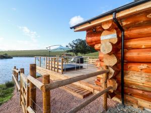 a wooden deck with a bench on the side of a lake at Cedar Cabin in Worcester