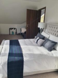 una camera da letto con un grande letto bianco con cuscini blu di Coille Darach B&B a Strontian