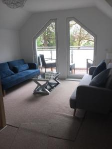 a living room with a blue couch and a table at Coille Darach B&B in Strontian