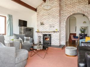 a living room with a brick fireplace at Ser a Mor Stars and Sea in Amlwch