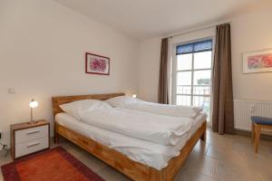 キュールングスボルンにあるHaus-Olymp-Wohnung-24-9506のベッドルーム1室(白いシーツ付きのベッド1台、窓付)