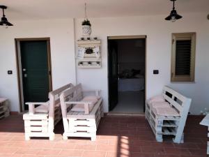 a porch with two rocking chairs and a bedroom at casa vacanza GIOIA in Civitanova Marche
