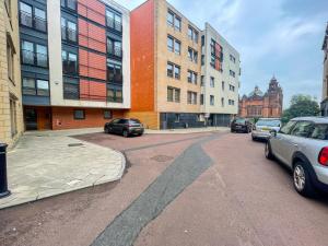 a city street with cars parked in front of buildings at Kelvingrove 2 Bedroom Apartment - Private Parking in Glasgow