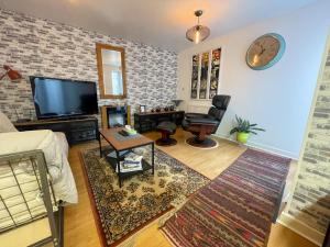 a living room with a couch and a tv at Kelvingrove 2 Bedroom Apartment - Private Parking in Glasgow