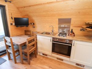 a kitchen with a table and a sink and a stove at Gander Pod in Worcester