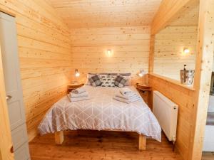 um quarto com uma cama num chalé de madeira em Badgers Sett em Darlington